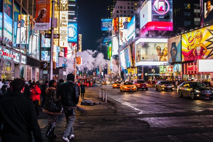 La ciudad de Nueva York llena de gente en medio de la noche con las luces de las tiendas encendidas