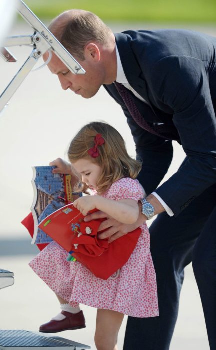 El príncipe William ayuda a la princesa Charlotte a subir los escalones del avión