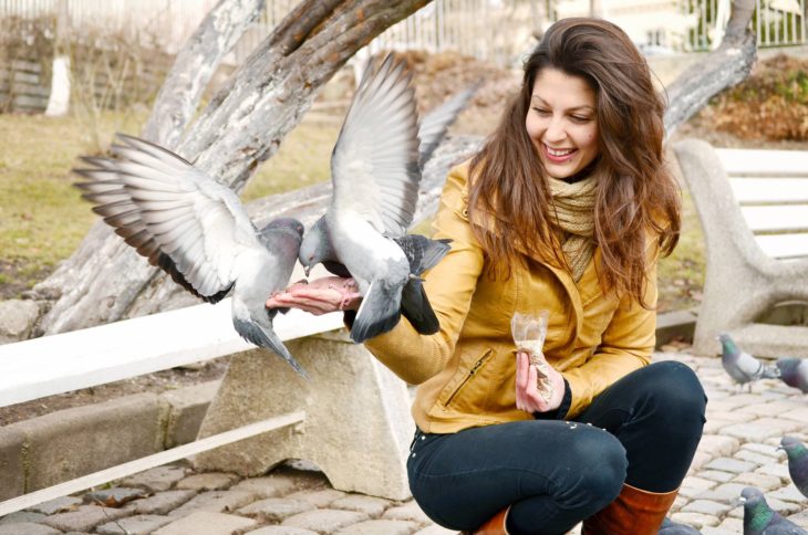 Mujer alimenta a las palomas