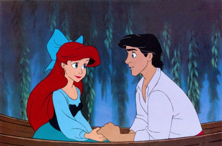 Escena de la película La Sirenita de Disney, Ariel y Eric tomados de las manos sobre una lancha de madera