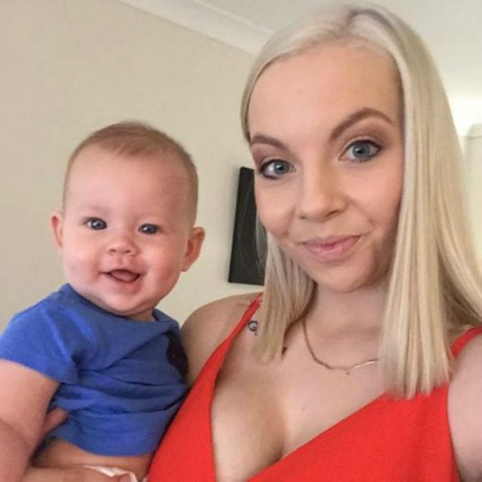 mujer rubia de vestido rojo y bebé con camisa azul
