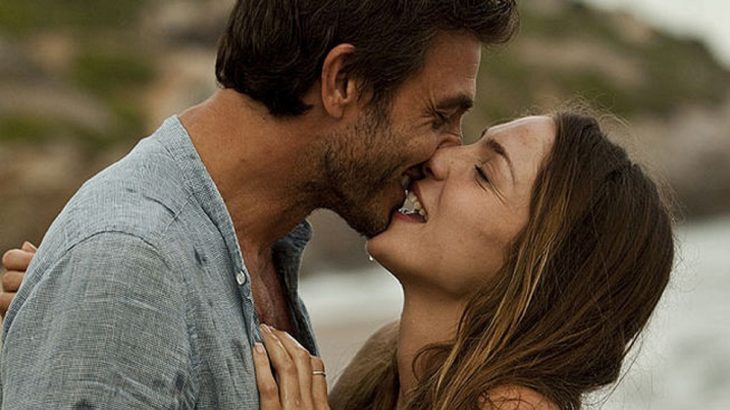pareja de frente dándose un beso feliz 