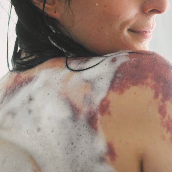 Mujer lavando su cuerpo con jabón 