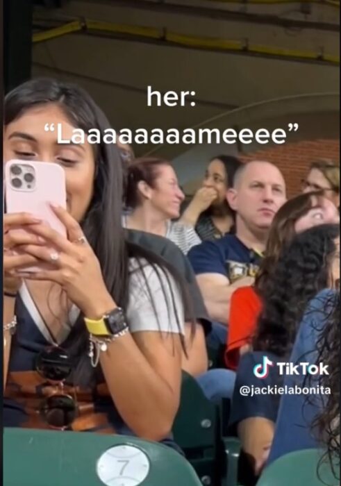 Chica burlándose de otra en estadio de béisbol