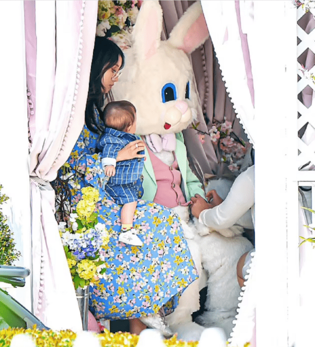Brenda Song sostiene a su hijo menor mientras posan para fotos con el conejo de Pascua