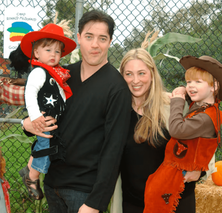 Brendan Fraser en una imagen junto a su ex esposa Afton Smith, llevando a dos de sus hijos pequeños en brazos. Los niños están vestidos de vaqueros mientras que sus padres lucen casual en color negro.