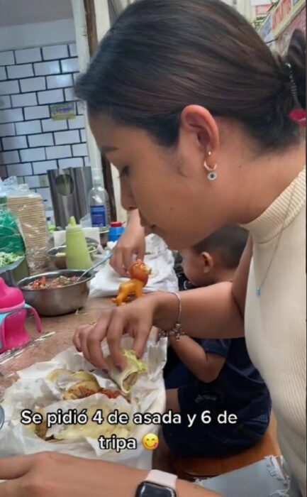 imagen de una chica comiendo tacos en un puesto dentro del mercado