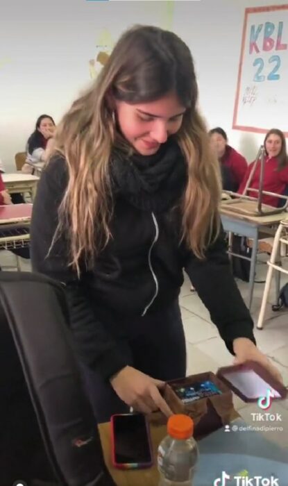 imagen de una chica abriendo un regalo de una compañera de clase