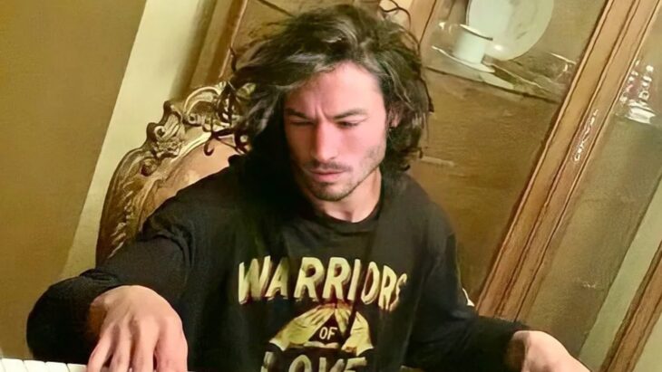 Foto del actor Ezra Miller sentado en una silla en lo que parece ser una sala de estar