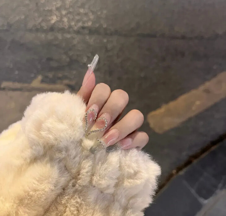 mano de una chica usando uñas acrílicas