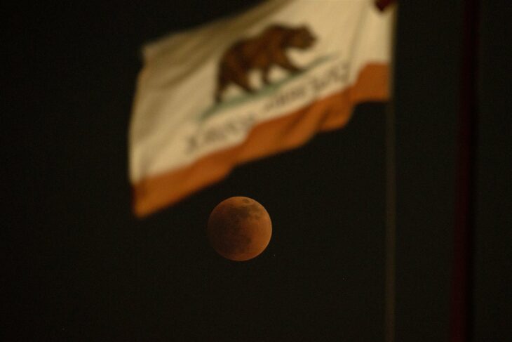 Luna roja vista desde la bandera de California en El Monte, California, Estados Unidos