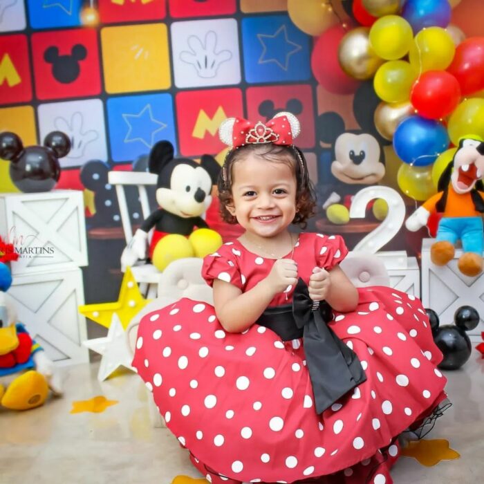 Niña que nació enojada posando para una fotografía vestida de Minnie Mouse