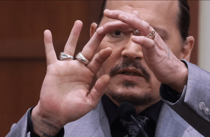Actor Johnny Depp sosteniendo su dedo medio herido