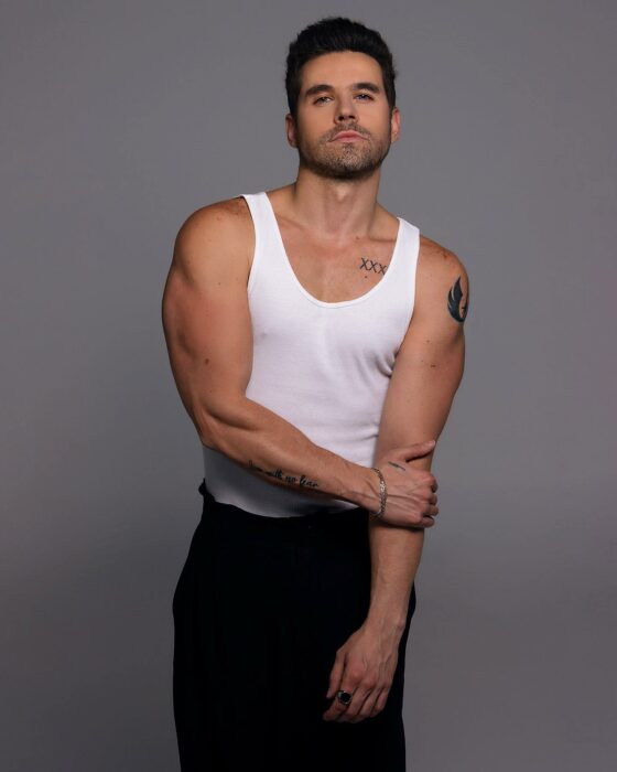 Actor Eleazar Gómez posando en camisa de tirantes blanca a juego con un pantalón negro