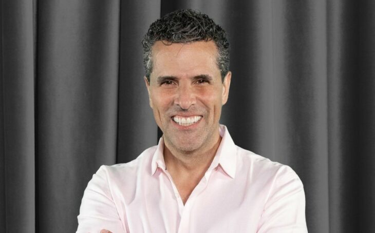 Marco Antonio Regil posa con una gran sonrisa, con cortinas grises de fondo