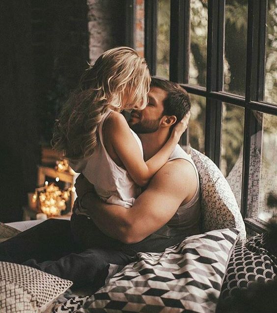 pareja de novios besándose en la cama