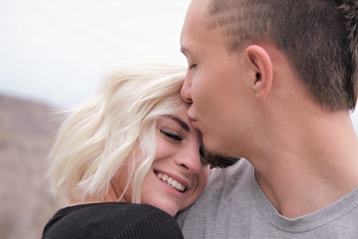 Chico besando a su novia en la frente