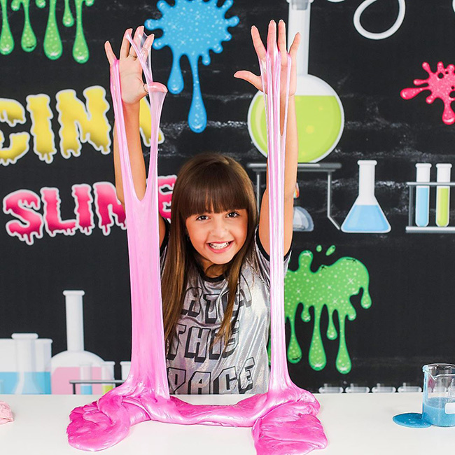 Niña jugando con slime de color rosa