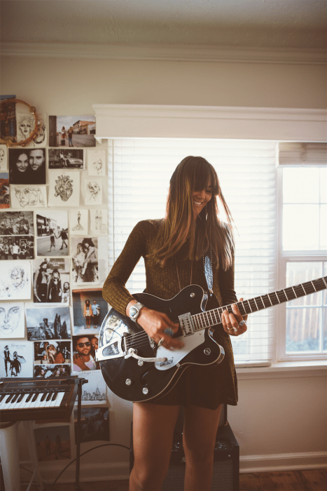 Chica tocando la guitarra eléctrica