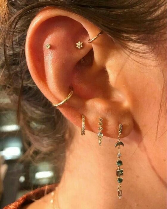chica con múltiples pendientes en el oído; 13 Creativas maneras de llevar más de un piercing en el oído