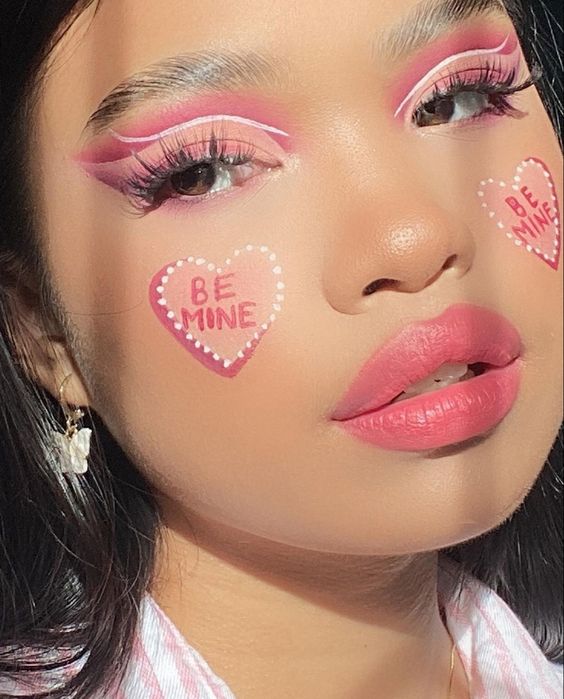 Chica con maquillaje rosa y corazones en las mejillas;