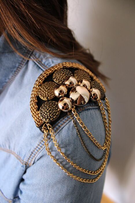 Chica con camisa de mezclilla y hombrera de tachuelas doradasHombreras para decorar tus prendas
