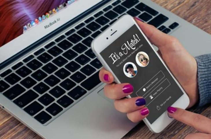 Manos de mujer haciendo match en Tinder a través de una pantalla táctil