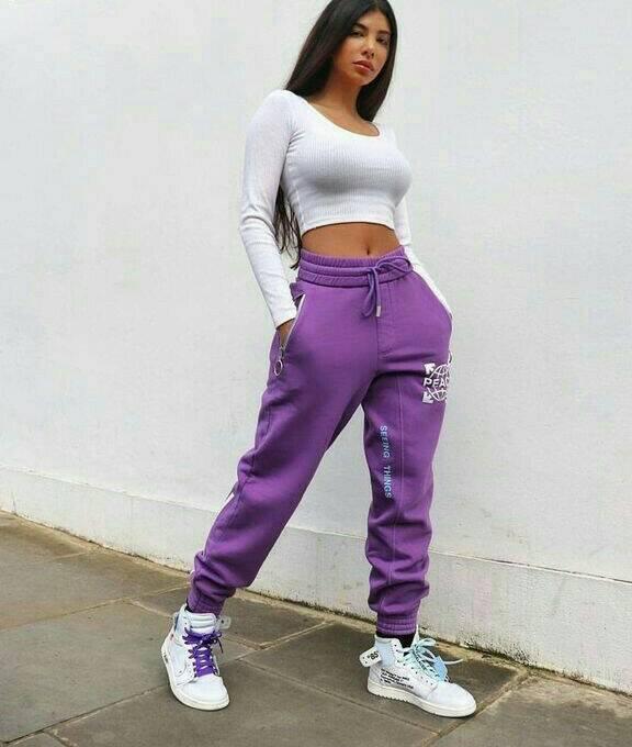 Chica con pantalones holgados en tono morado y top blanco; 13 Ideas para usar pantalones holgados sin perder el estilo