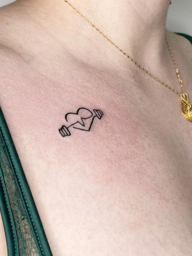 Chica con un tatuaje en el brazo de un corazón con una pesa 