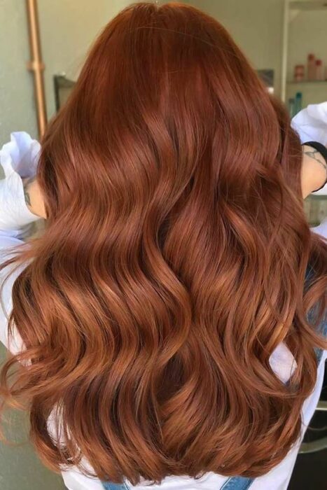 Chica con cabello largo mostrando su tinte en tono Brick Brown