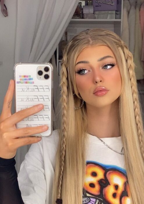 chica sosteniendo celular ;14 Peinados con trencitas al frente para unas fotos aesthetic