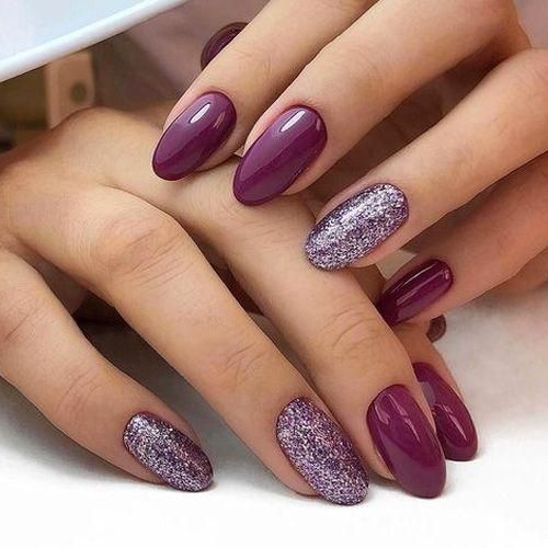 manos de mujer con manicura en tonos morado con efecto glitter