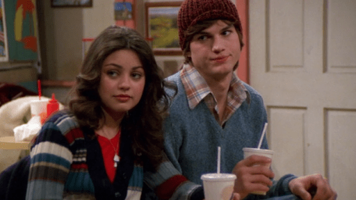 Ashton Kutcher y Mila Kunis sentados en un sofá en Thats 70's show