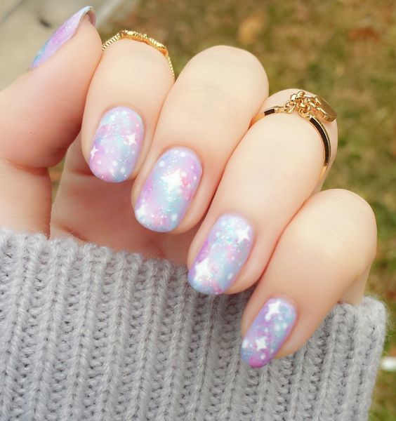 Uñas en tonos pastel con diseño galaxia