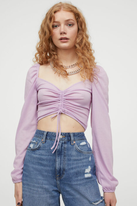 Chica con una blusa de color morado con jeans