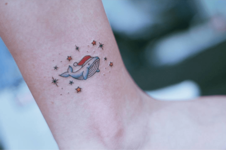Tatuaje de una ballena con gorro navideño