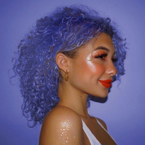 Chica con el cabello rizado y teñido de color morado