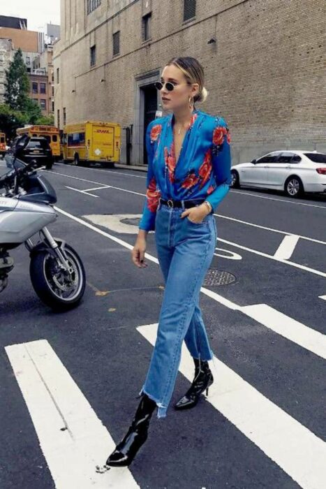 Chica usando una blusa de satín de color azul con flores rojas