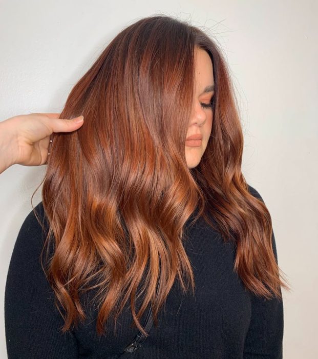 Chica con el cabello de color cobrizo y reflejos en color naranja
