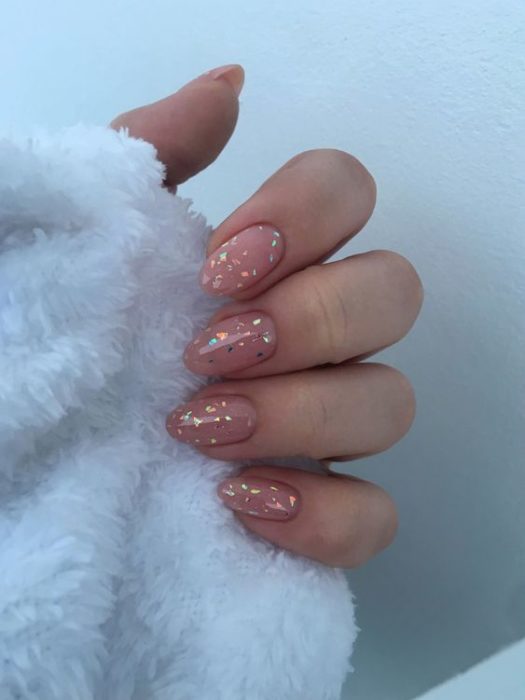 Diseño de manicura en uñas cortas en fondo nude con detalles brillantes