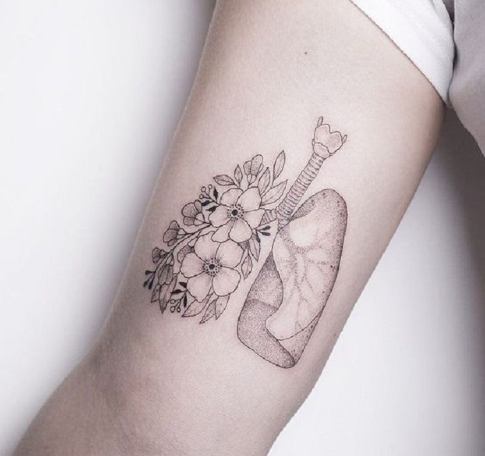 Tatuaje en la parte interna del brazo, de unos pulmones, uno de ellos con flores
