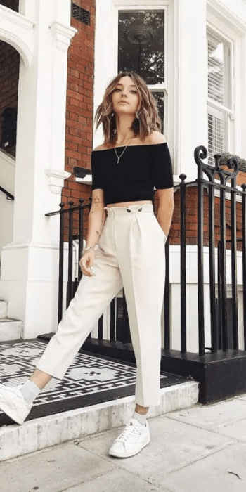 Chica usando un pantalón beige, top crop y tenis