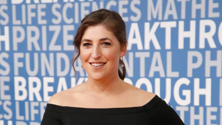 Mayim Bialik sonriendo ligeramente en una alfombra roja de The Big Bang Theory