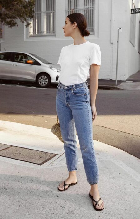 Chica usando unas sandalias flip flops con un pantalón de mezclilla