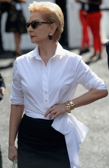 Carolina Herrera usando una camisa de botones con una falda negra