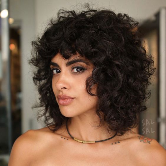 Chica morena con cabello rizado y melena corta