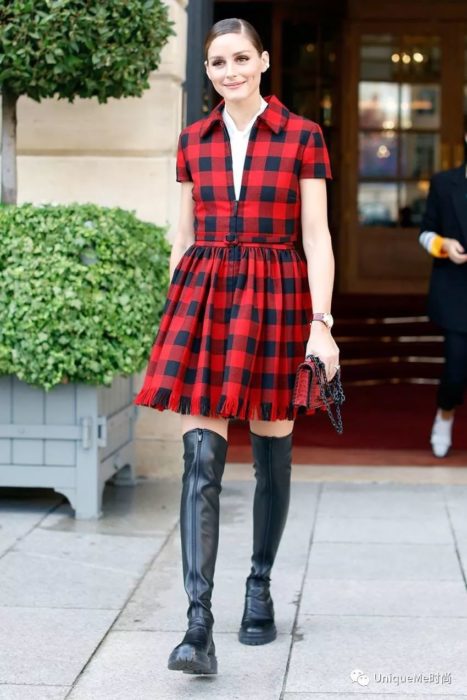 Chica caminando por la calle con botas largas negras