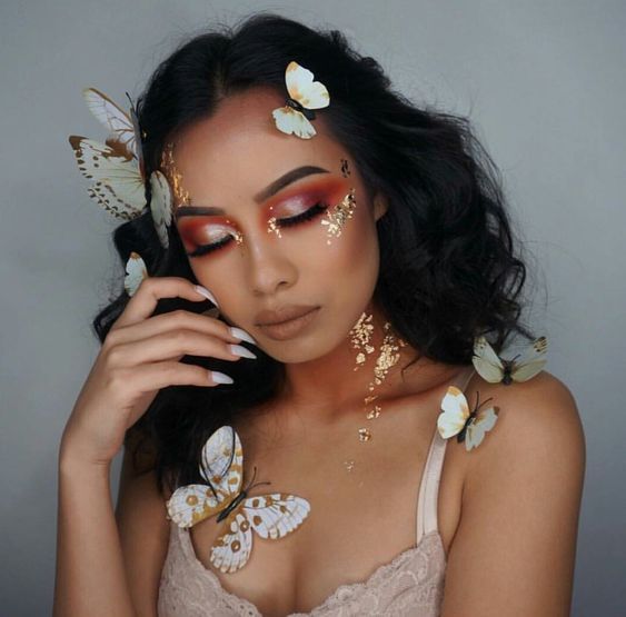 Chica con maquillaje casual y mariposas pegadas en el rostro