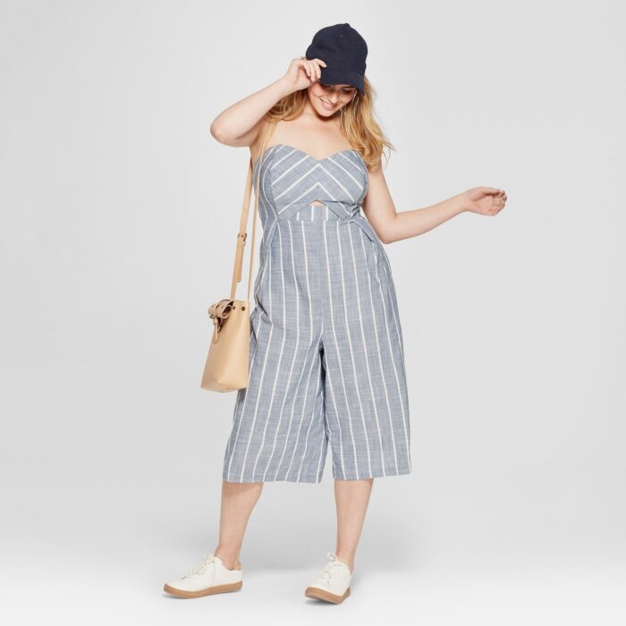 Chica usando un jumpsuit de color gris con líneas blancas y unos sneakers de color blanco