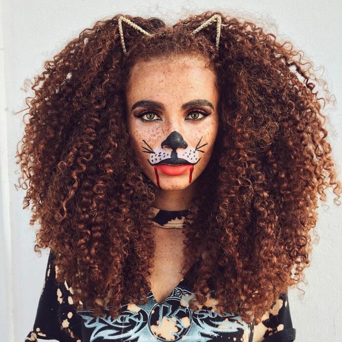 Chica con el cabello rizado y una diadema de gatito